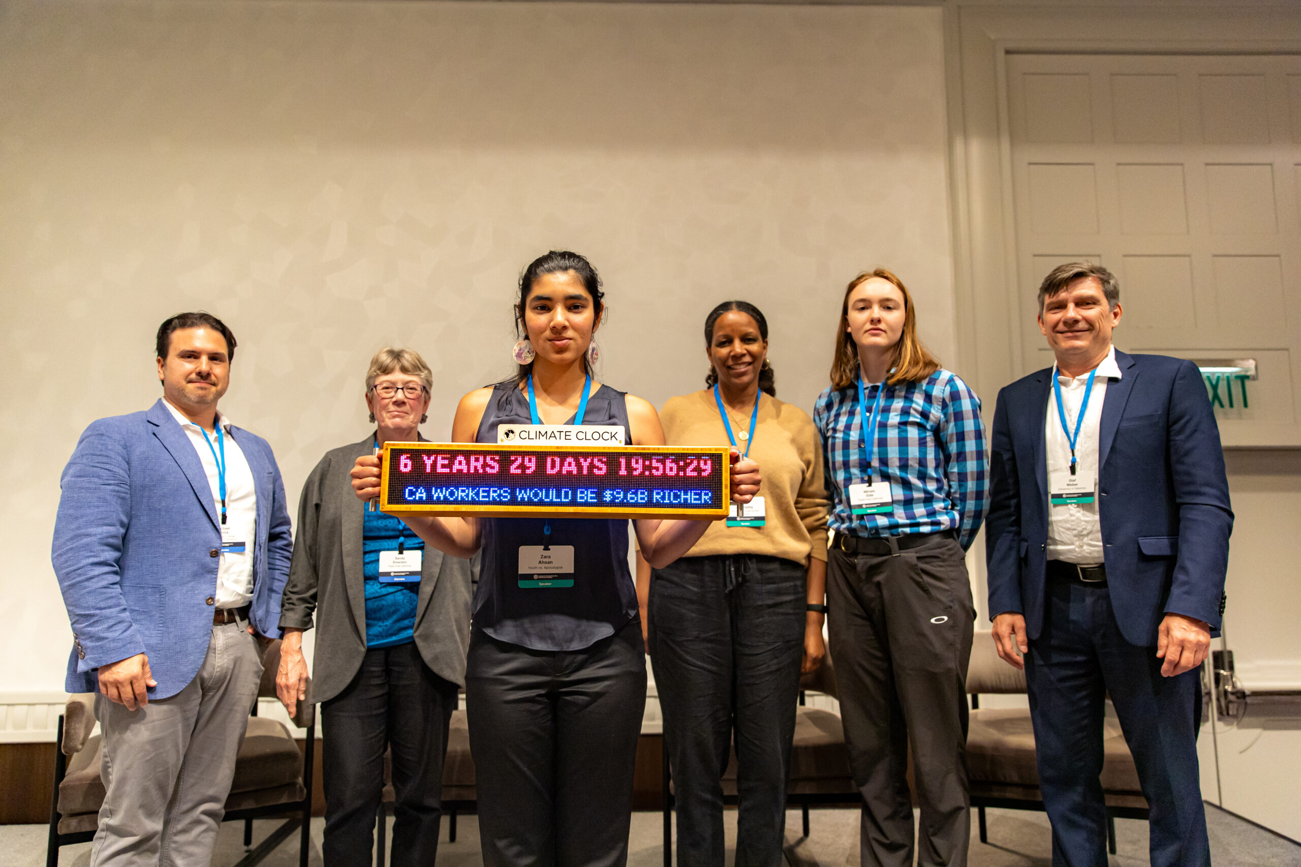 Group of 6 panelists from California divestment panel at IEEFA Conference with portable Climate Clock featured.